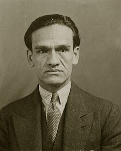 Formal portrait of César Vallejo in a dark suit, striped shirt, and dotted tie