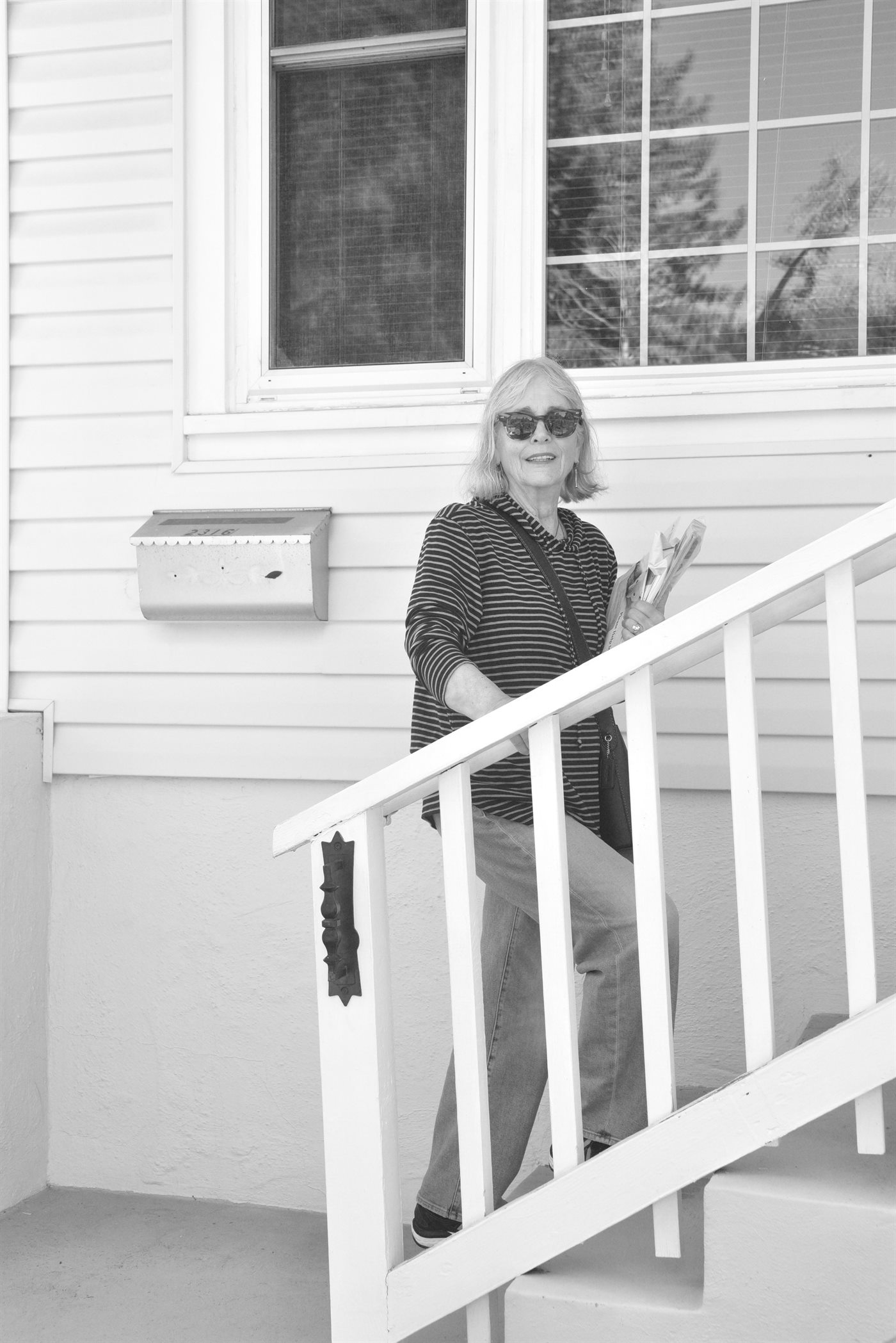 Cathryn Shea on the steps of a white house, papers in her hand