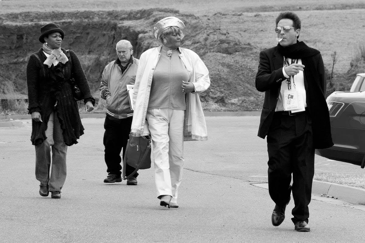 Louis Bourgeois walking at the right of a group crossing a lot